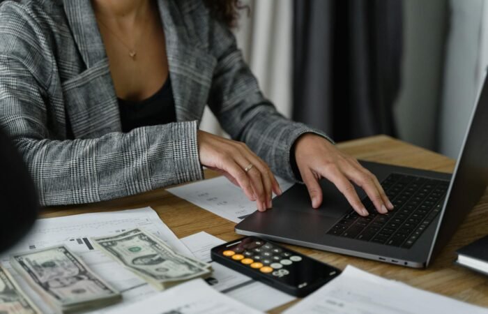 A Woman in Plaid Blazer Using Her Laptop